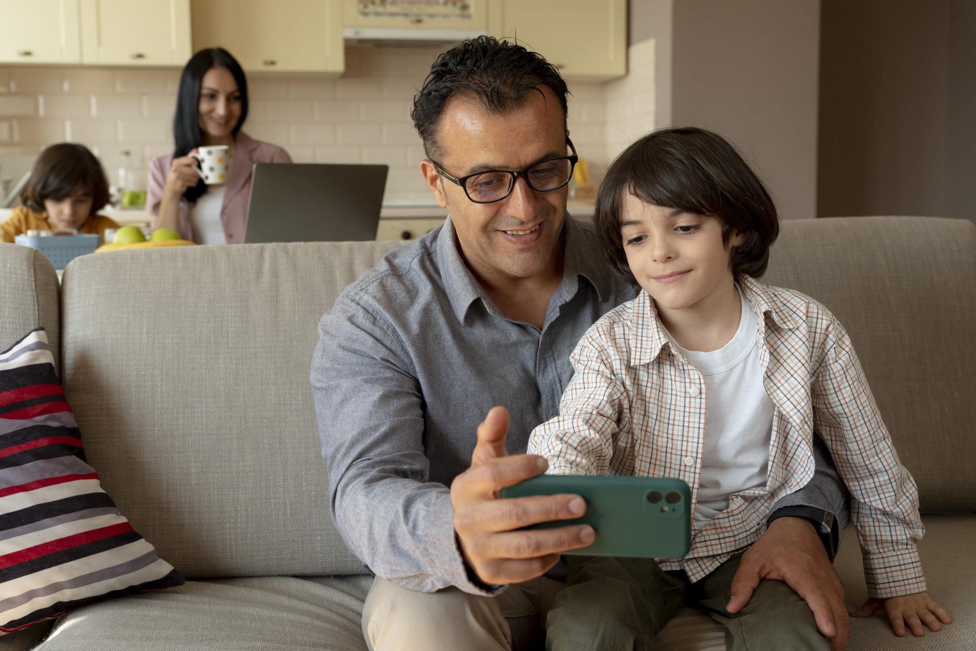 father-son-looking-smartphone-home